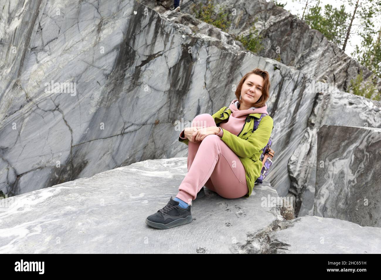 Frau sitzt auf Marmorplatte im italienischen Steinbruch, Ruskeala, Karelia Stockfoto