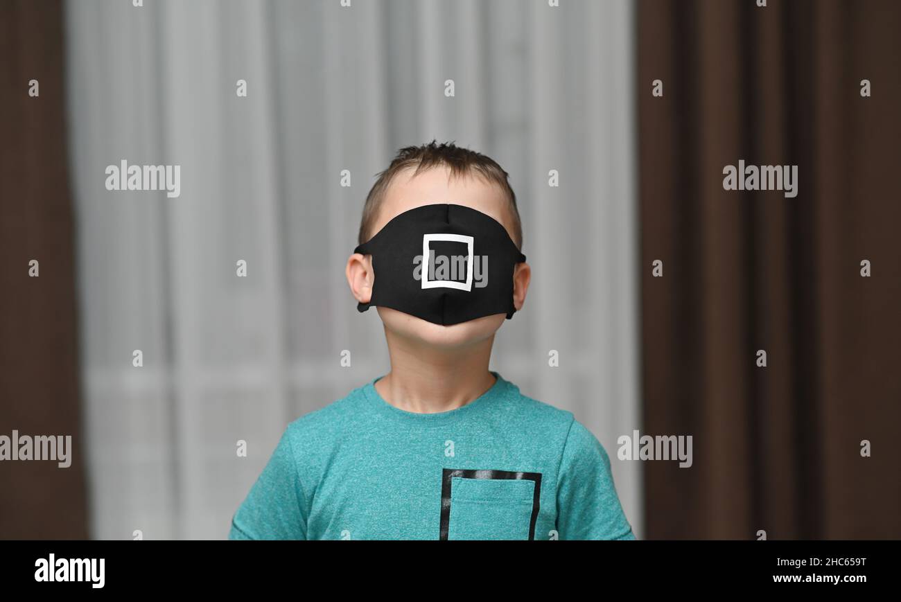 Eine medizinische Schutzmaske bedeckte das Gesicht des Jungen. Stockfoto