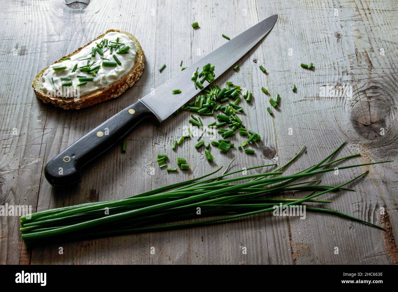 Küchenmesser mit geschnittenem Lauch auf Holzhintergrund Stockfoto