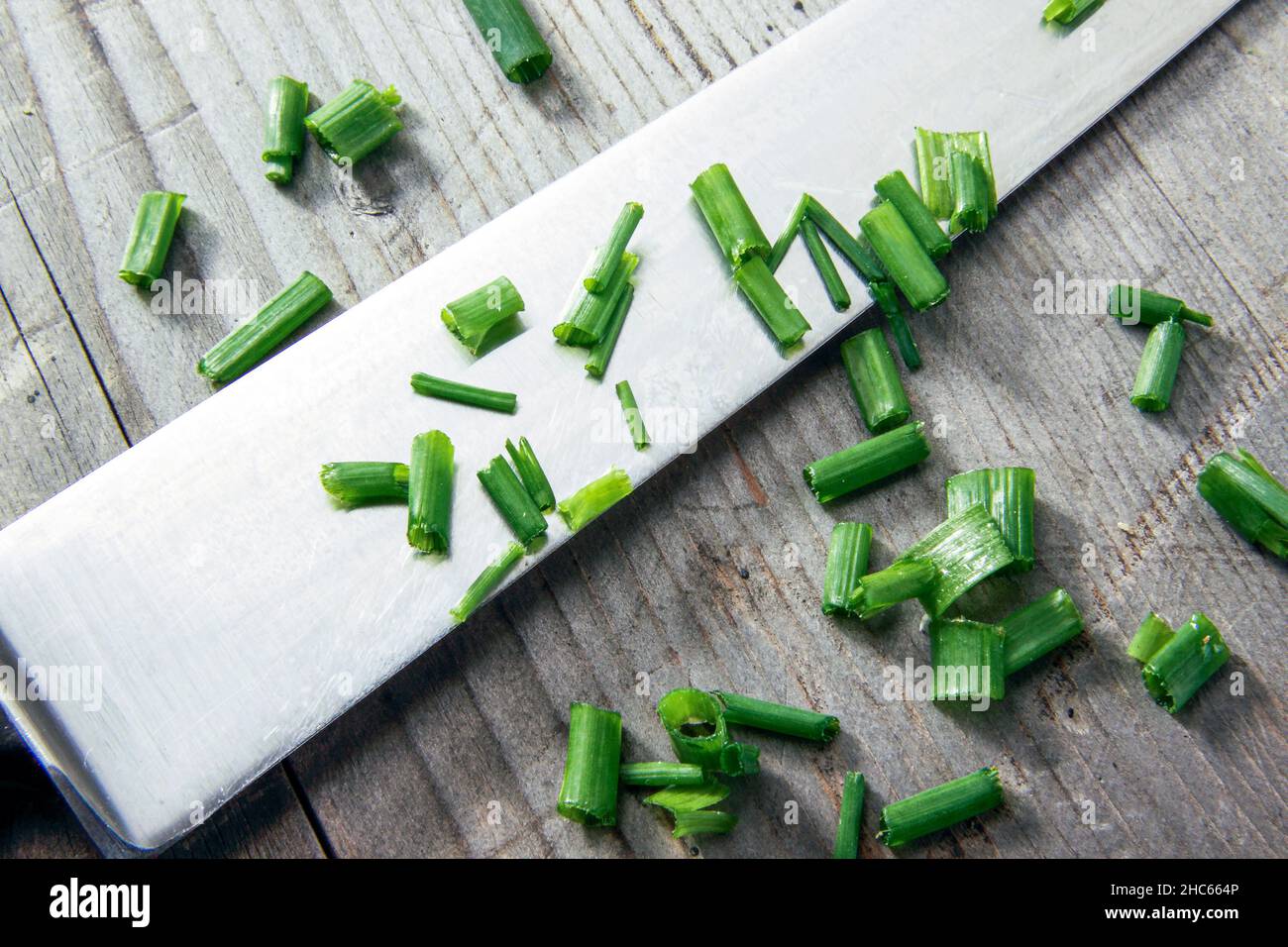 Küchenmesser mit geschnittenem Lauch auf Holzhintergrund Stockfoto