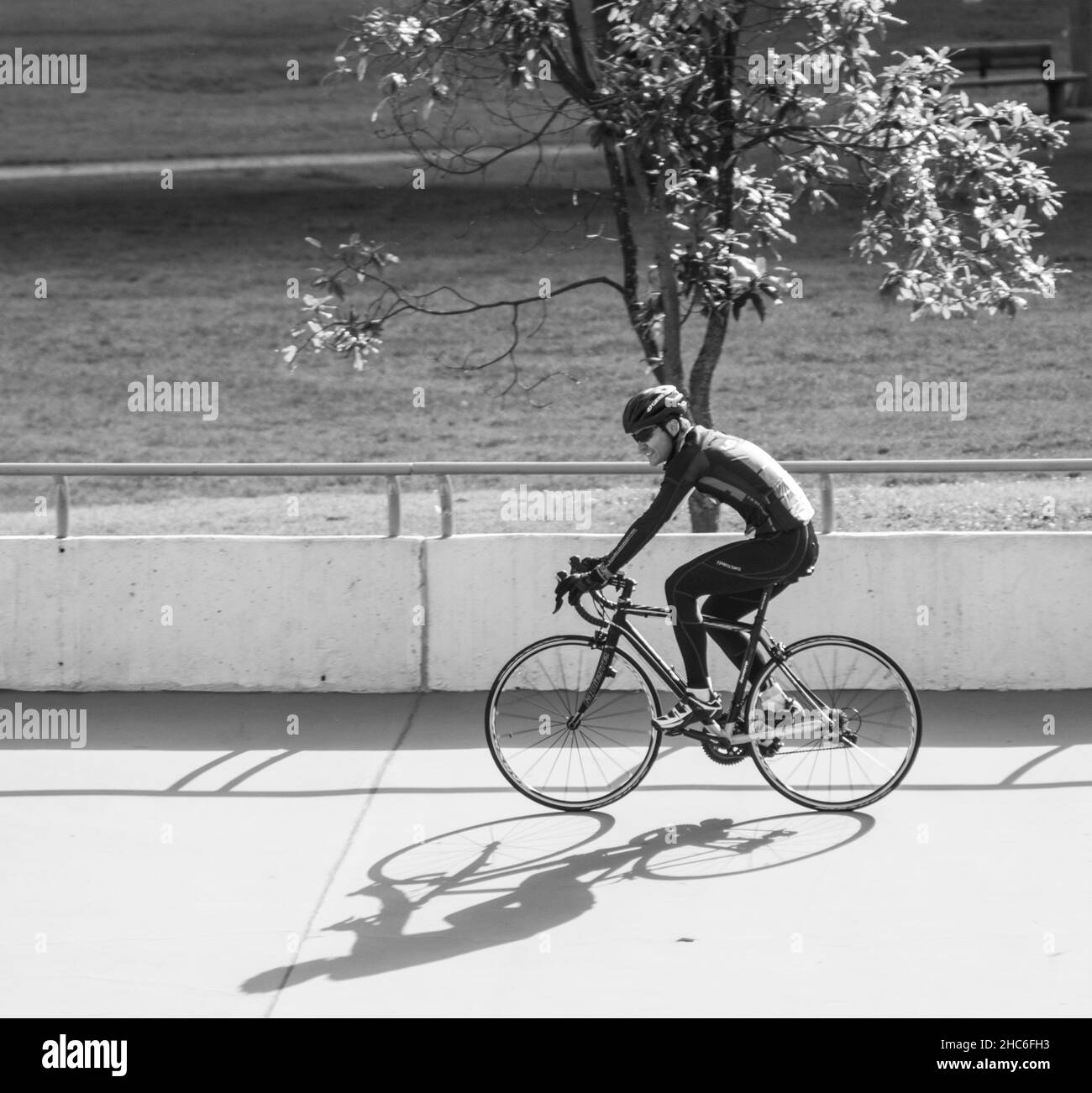 Hohe Winkel Graustufen eines Radfahrers auf der Straße Radtraining auf der Strecke Stockfoto
