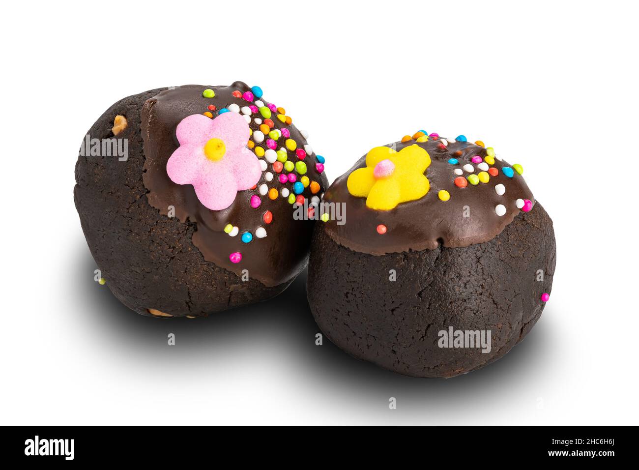 Choc-Kugeln oder Schokoladenkugeln mit bunten Regenbogenstreuseln und farbigen Zuckerblumen auf weißem Hintergrund mit Clipping-Pfad isoliert. Stockfoto