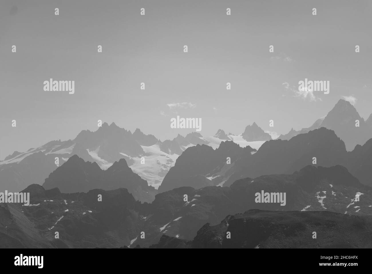 Wunderschöne Graustufenaufnahme von verschneiten Berggipfeln Stockfoto