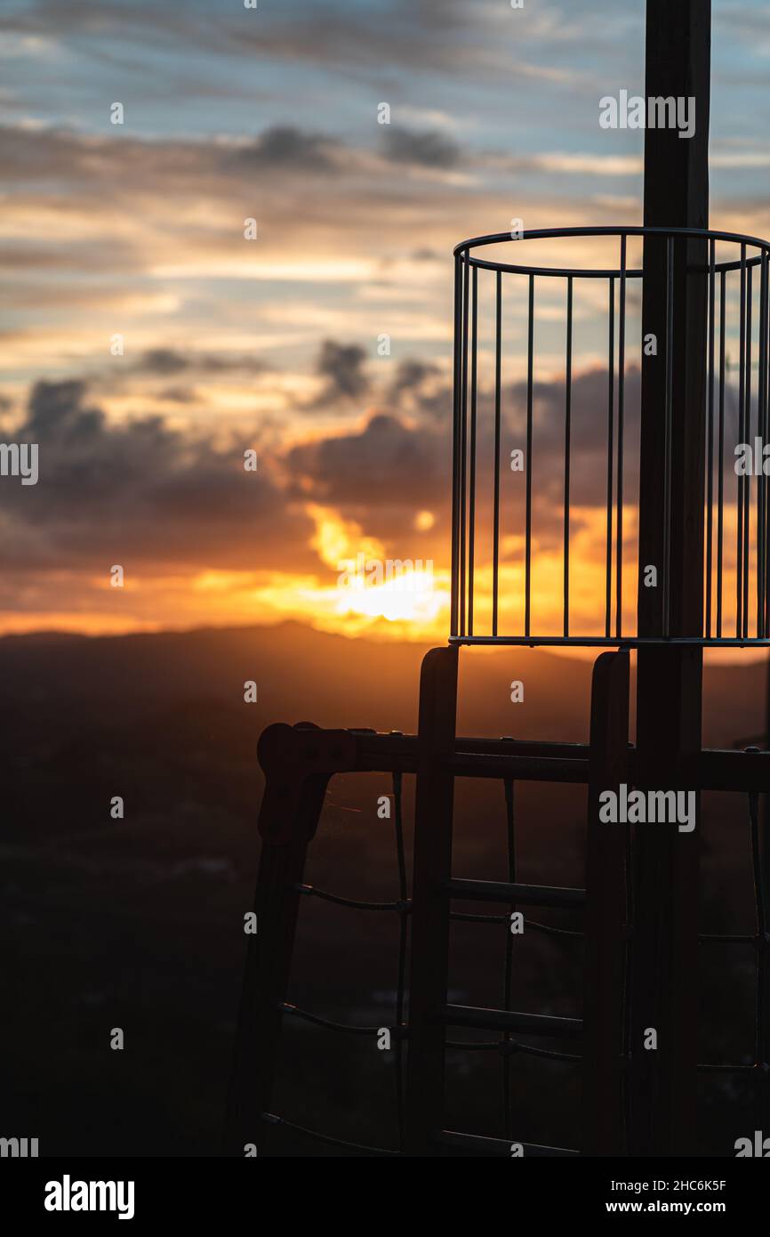 Vertikaler selektiver Fokus von Metallkonstruktionen auf einem farbenfrohen Hintergrund bei Sonnenuntergang Stockfoto