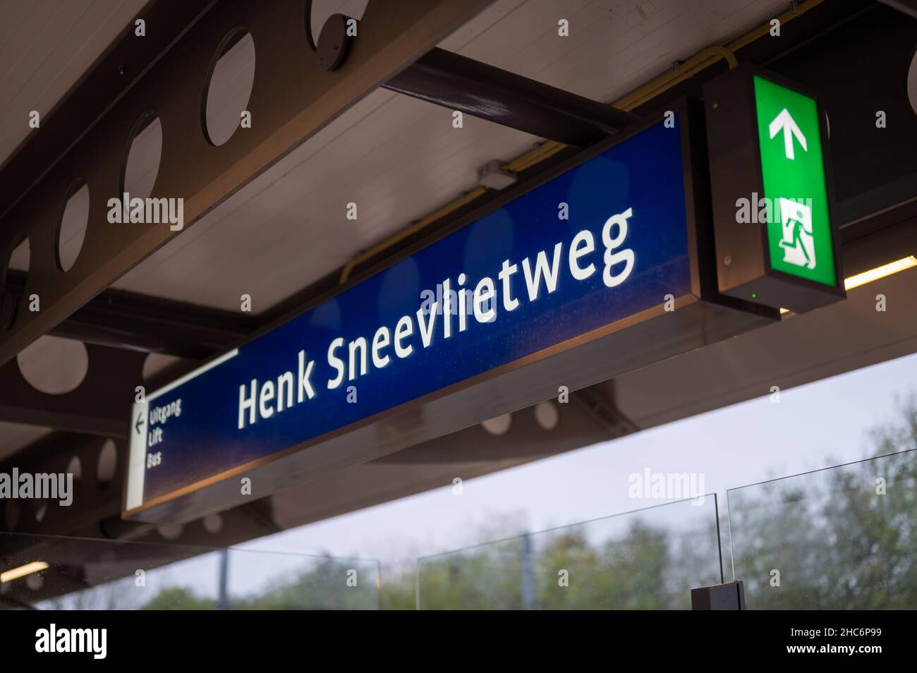 Schild für die U-Bahnstation Henk Sneevliegweg mit einem Notausgangsschild in Amsterdam, Stockfoto