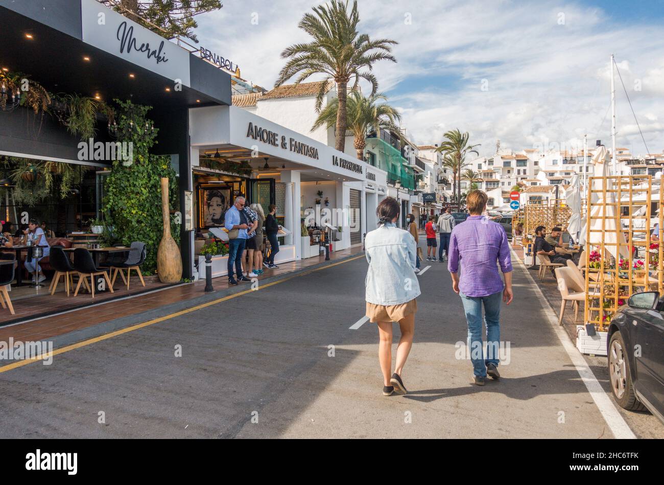 Menschen zu Fuß in Puerto Banus Hafen, mit Geschäften und Restaurants, Marbella, Andalusien, Costa del Sol, Spanien Stockfoto