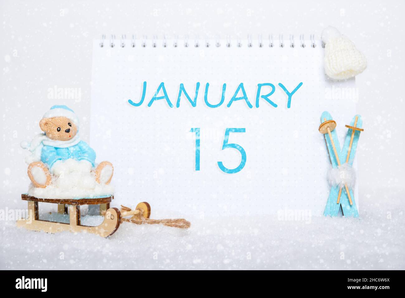 Januar 15th. Teddybär auf einem Schlitten, blaue Skier und ein Kalenderdatum auf weißem Schnee. Tag 15 des Monats. Wintersportkonzept. Wintermonat, Tag von Stockfoto
