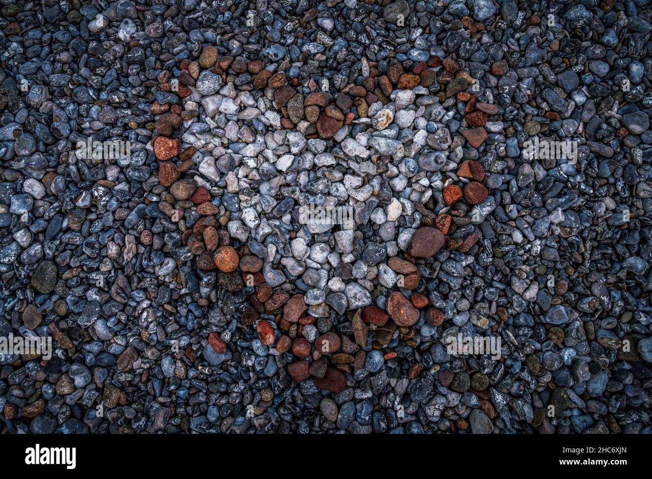 Herz aus Stein - Steine in der Form eines Herz in der Mitte von anderen Steinen Stockfoto
