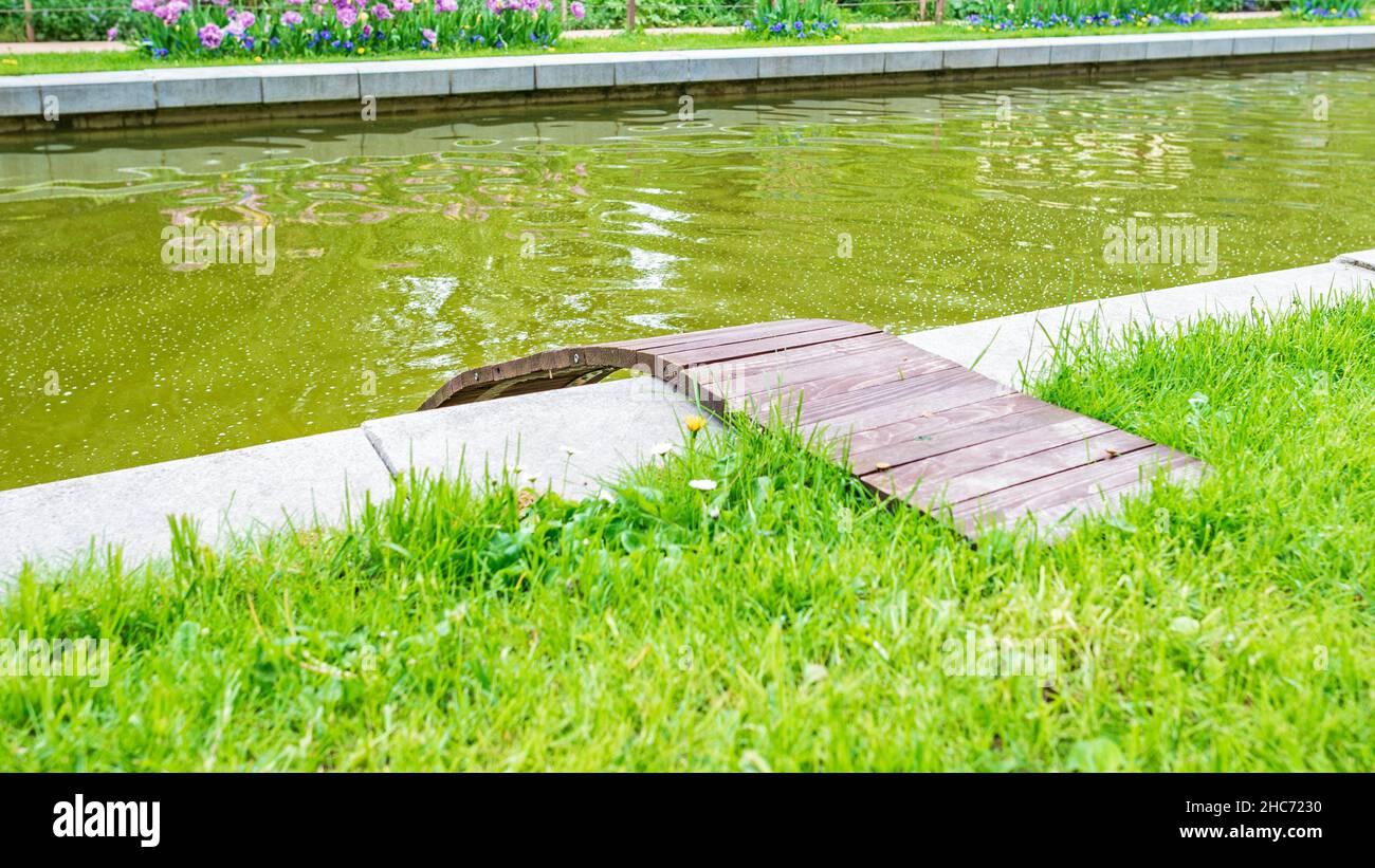 Kleine Holzbrücke für Enten in der Nähe des Teiches Stockfoto