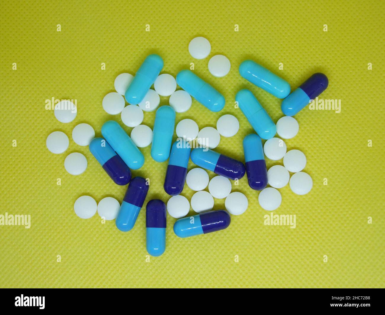 Nahaufnahme von Antibiotika-Kapseln und -Pillen auf gelbem Hintergrund Stockfoto