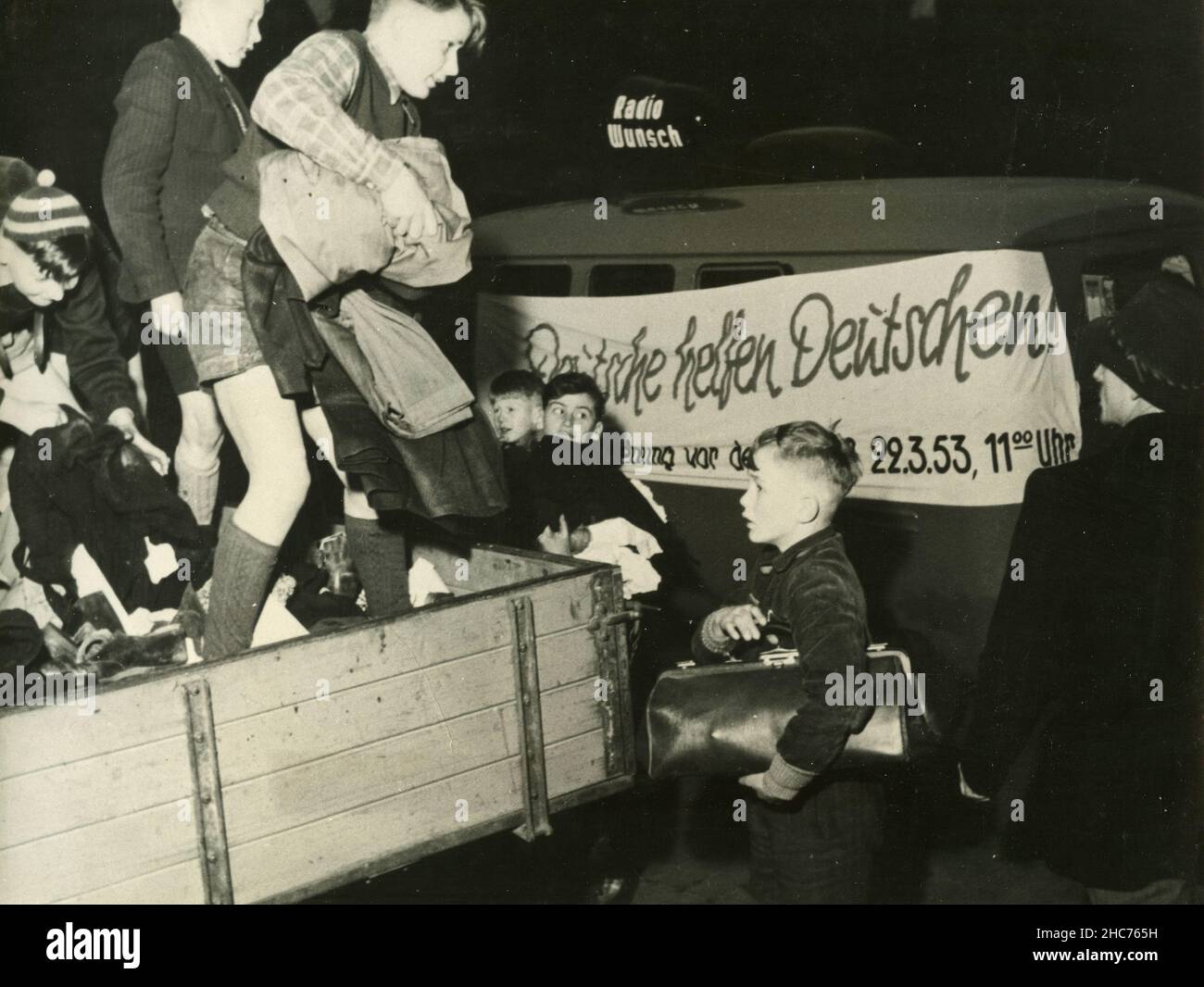Deutsche helfen Deutschen: Kinder aus Westdeutschland verteilen Kleidung und Hilfsmittel an Ostdeutsche, Celle, Deutschland 1953 Stockfoto