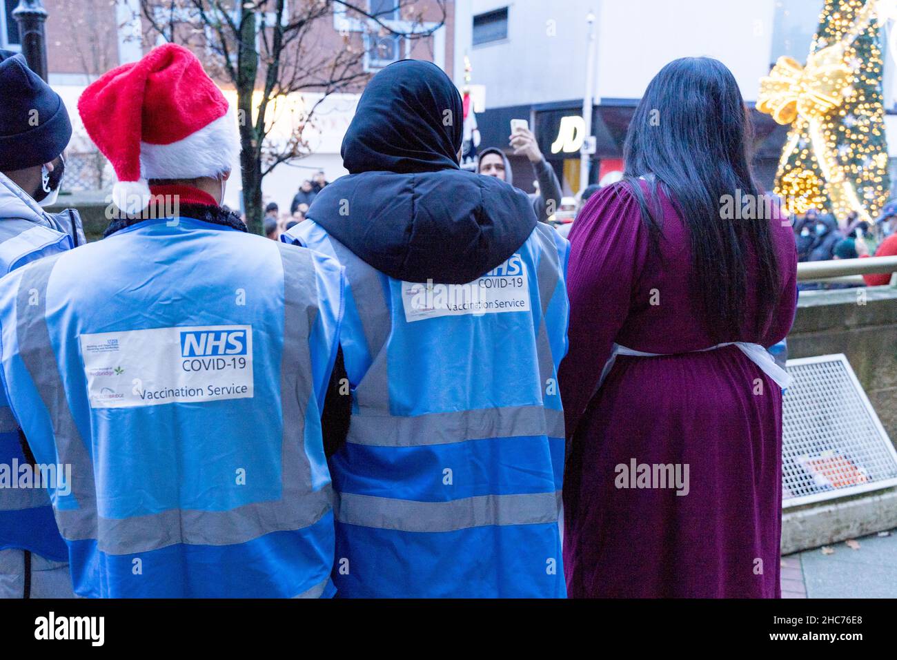 London, Großbritannien 25December 2021. NHS-Mitarbeiter und ehrenamtliche Mitarbeiter der Gemeinde verbringen ihren Weihnachtstag im Rathaus von Redbridge und bieten Coronavirus-Impfstoff und Jingle Jab für alle qualifizierten Personen als bestes Weihnachtsgeschenk seiner Art an. Sie schützen alle, da sich Omicron-Fälle alle zwei Tage verdoppeln. Quelle: Xiu Bao/Alamy Live News Stockfoto