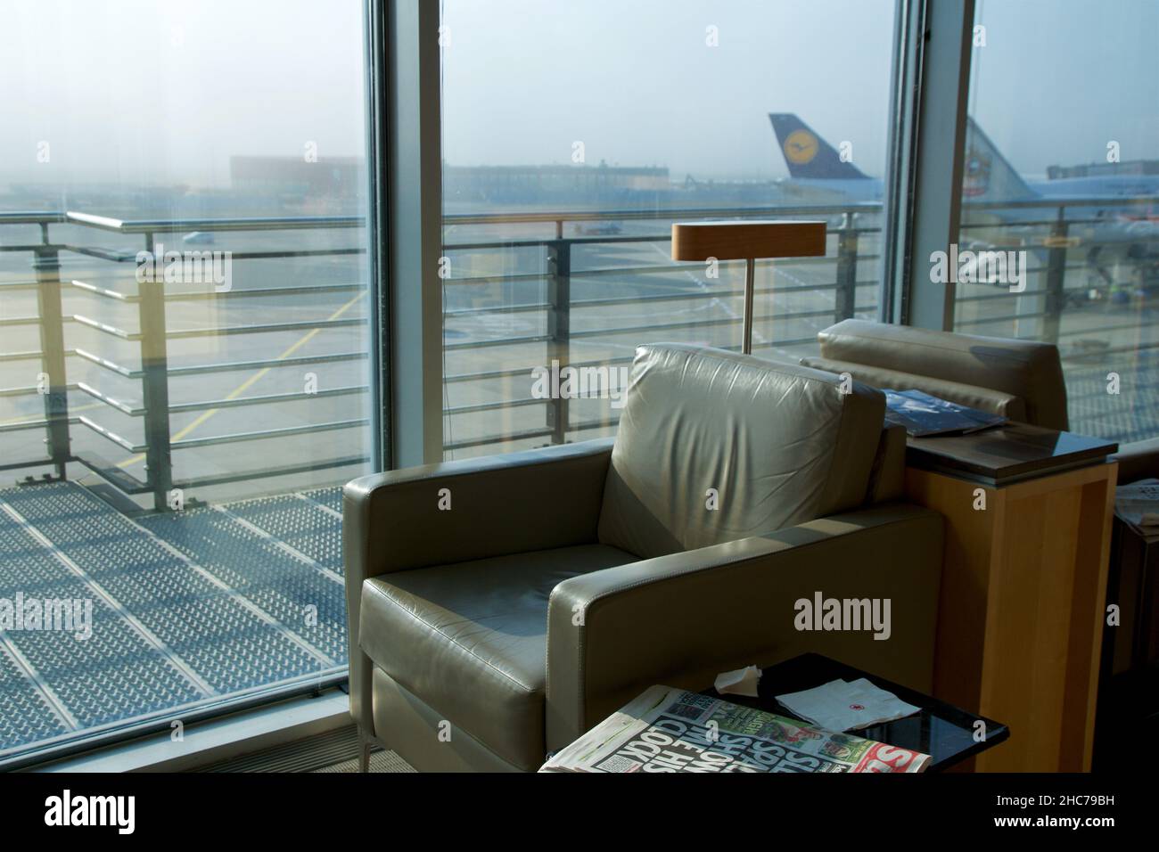 FRANKFURT, DEUTSCHLAND - 11 NOV 2017: Komfortabler Lounge-Sessel mit hellbraunem Leder in der Vielfliegerlounge des Flughafens mit Blick auf die Stockfoto
