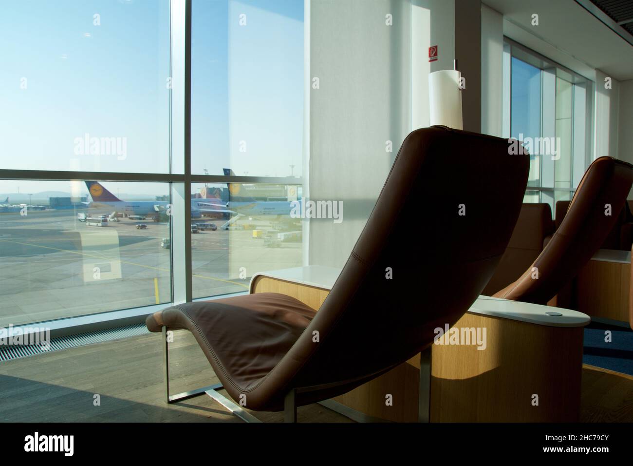 FRANKFURT, DEUTSCHLAND - 11 NOV 2017: Komfortabler Lounge-Sessel mit hellbraunem Leder in der Vielfliegerlounge des Flughafens mit Blick auf die Stockfoto