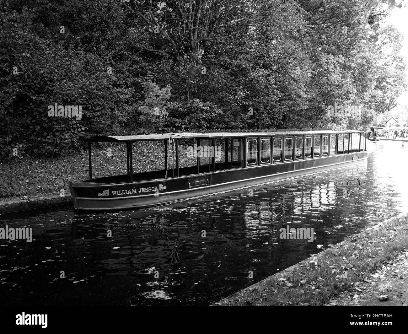 Graustufen eines Schmalbootes auf dem fließenden Fluss in der Stadt Llangollen Stockfoto