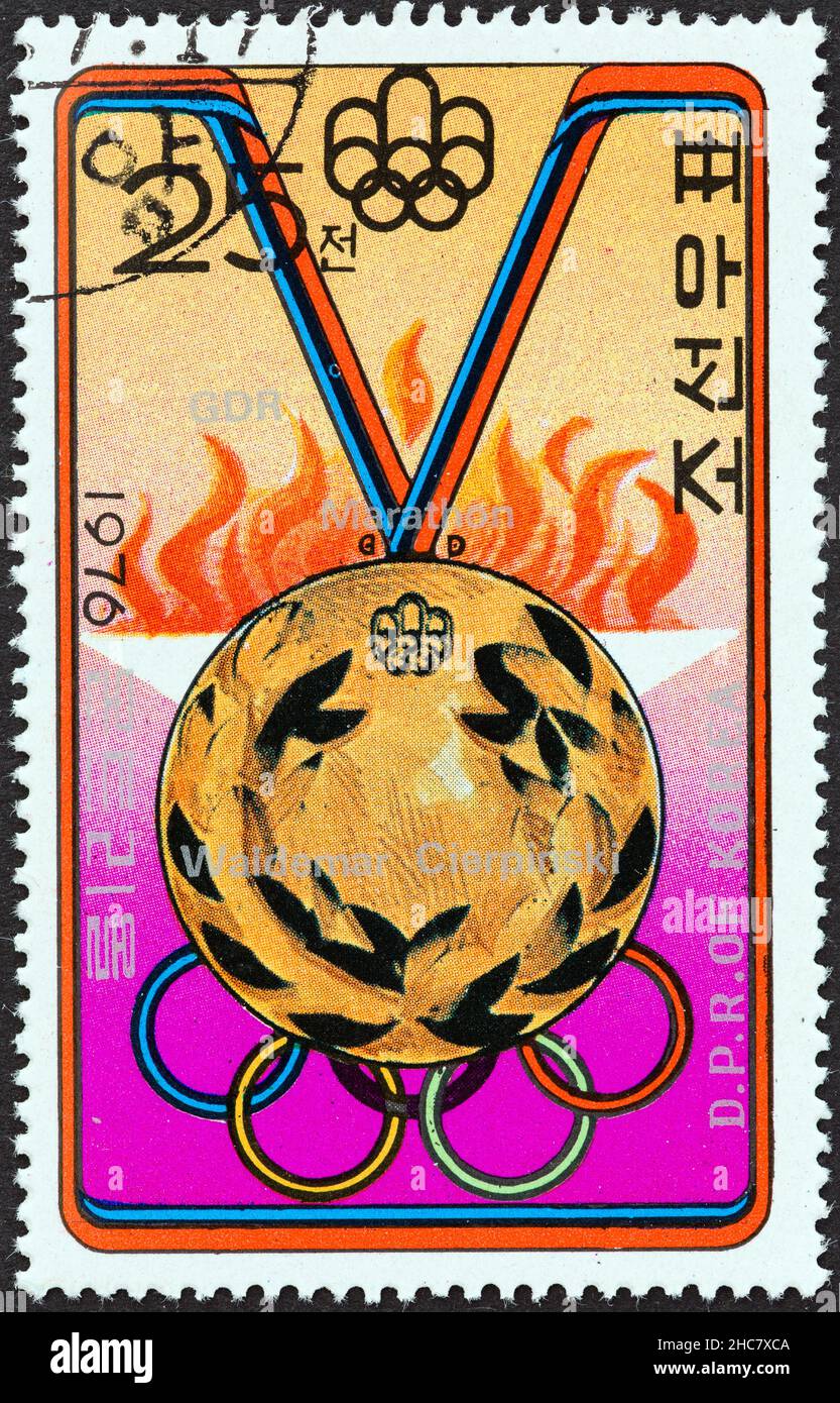 NORDKOREA - UM 1976: Eine in Nordkorea gedruckte Marke aus der Ausgabe 'Olympic Medal Winners' 1st zeigt Goldmedaille (Marathon, Waldemar Cierpinski) Stockfoto