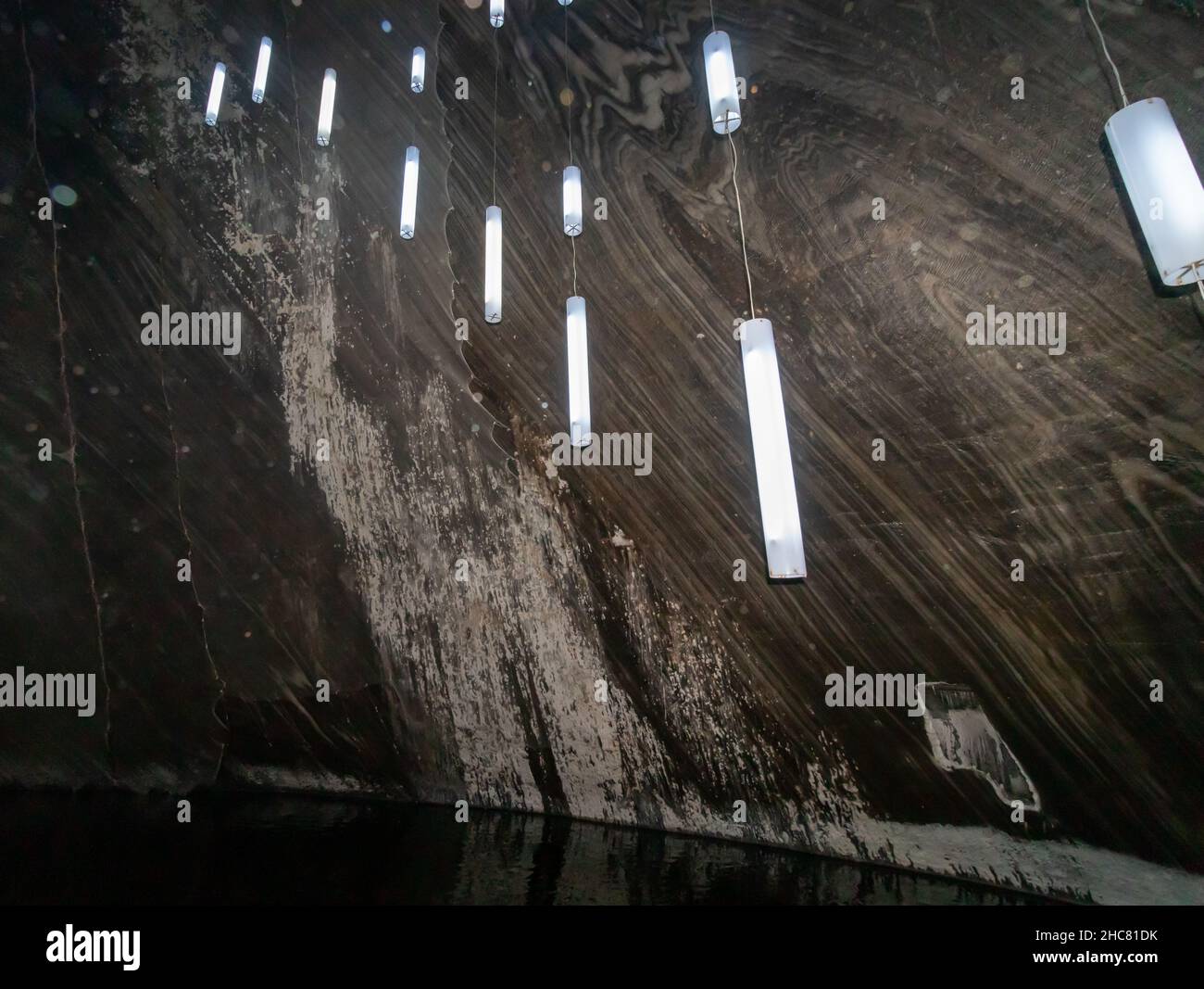 Nahaufnahme mit der Textur einer Salzwand in der Salzmine Turda, die von an der Wand hängenden LEDs beleuchtet wird Stockfoto