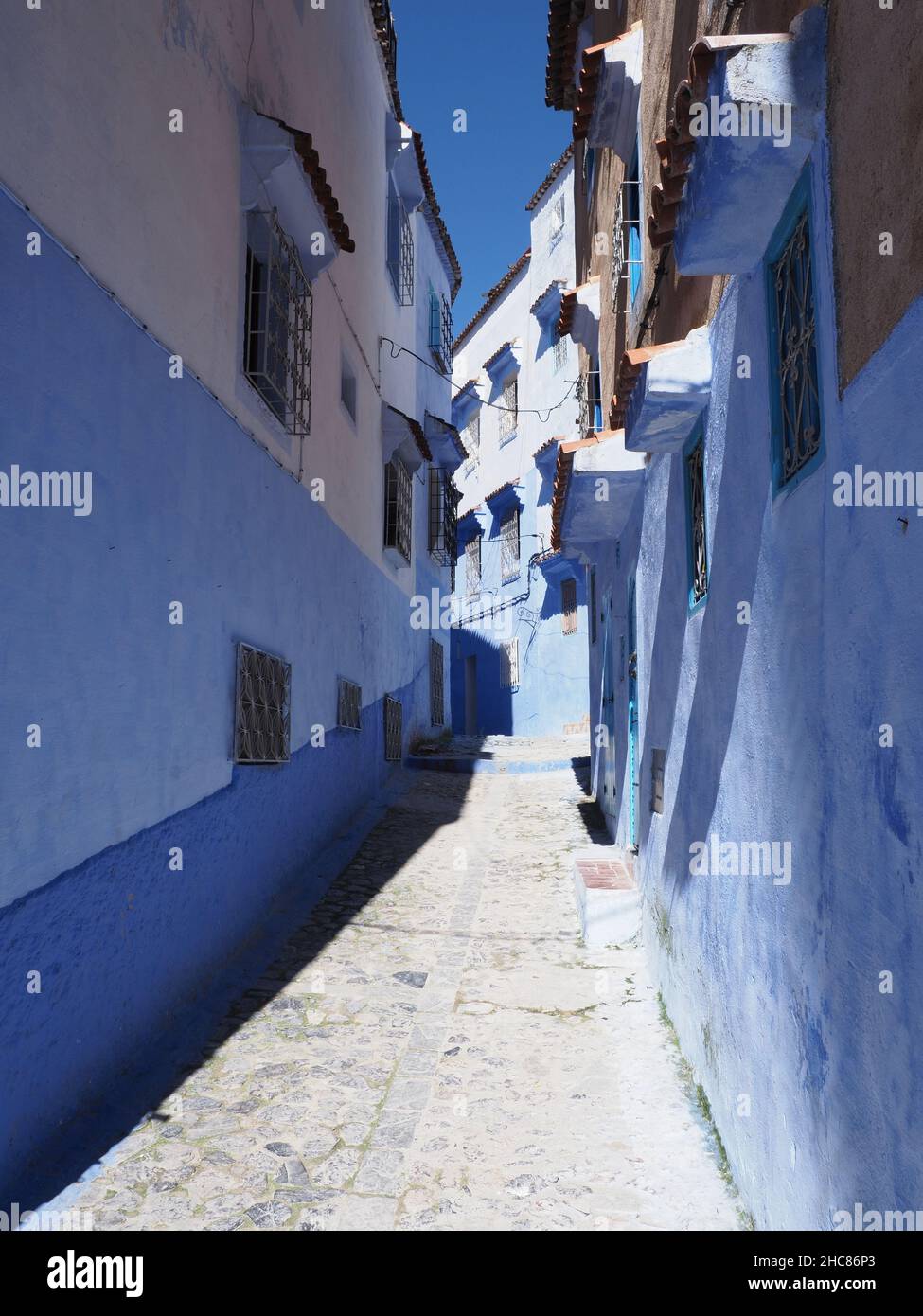 Gemütliche marokkanische Gasse in afrikanischen Chefchaouen Stadt in Marokko, klaren blauen Himmel in 2019 warmen sonnigen Frühlingstag am April - vertikal Stockfoto