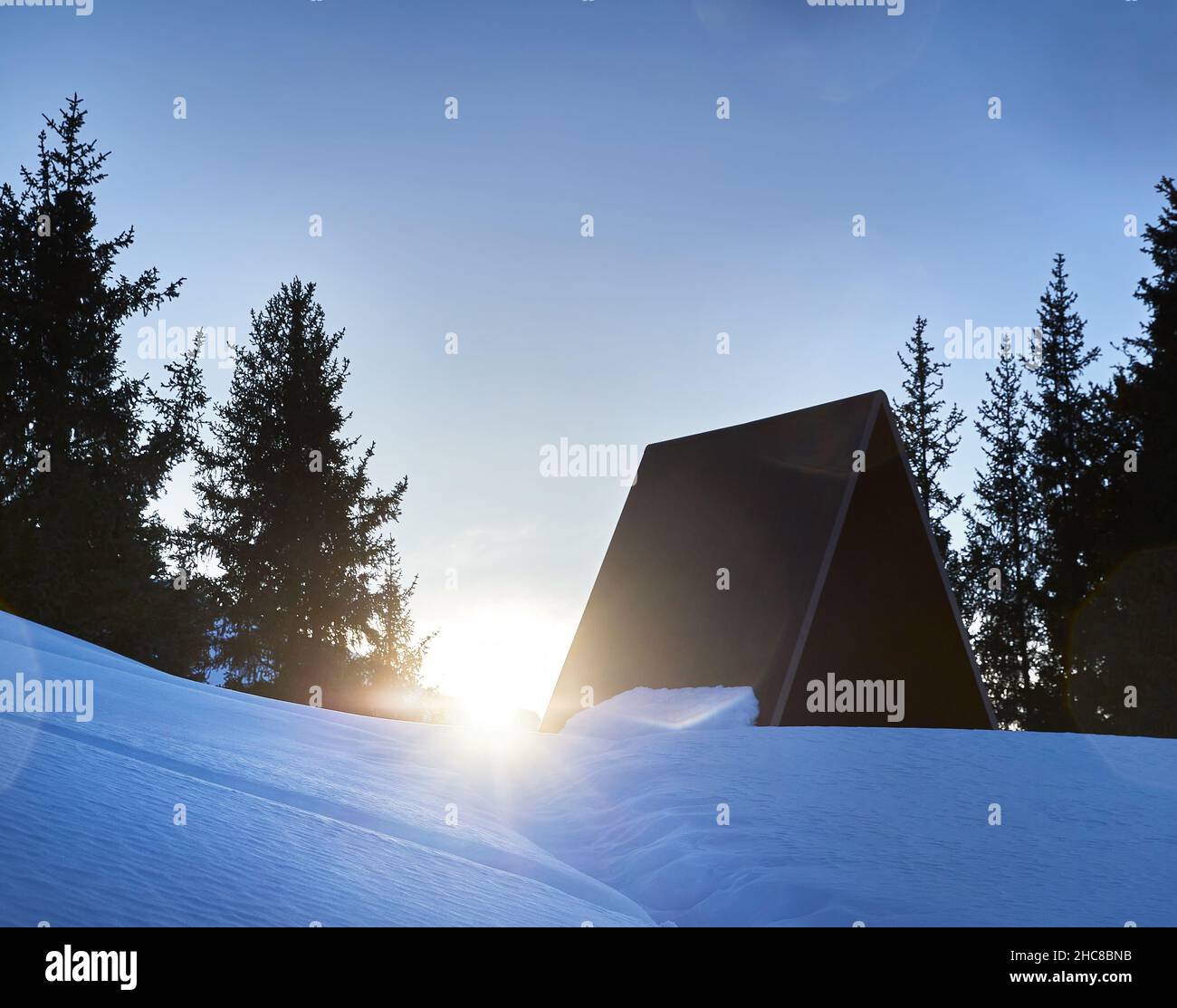 Schöne Winterlandschaft des Camp House am verschneiten Berg mit glühender Sonne in Almaty mit Fichtenwald gegen blau bewölkten Himmel in Kasachstan Stockfoto