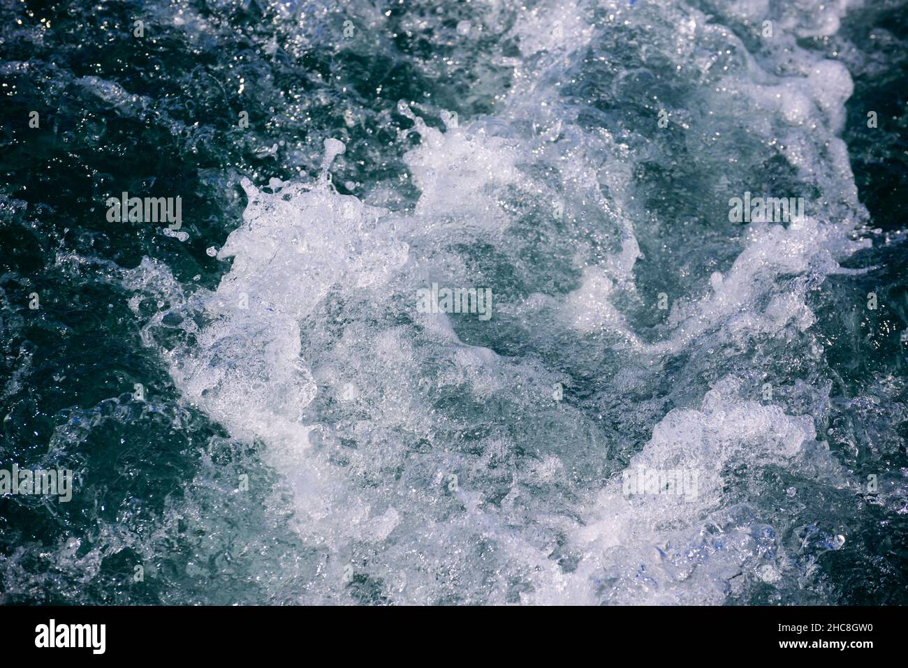 Weißer Kamm einer Meereswelle. Selektiver Fokus. Geringe Schärfentiefe. Abgeschwächt. Stockfoto