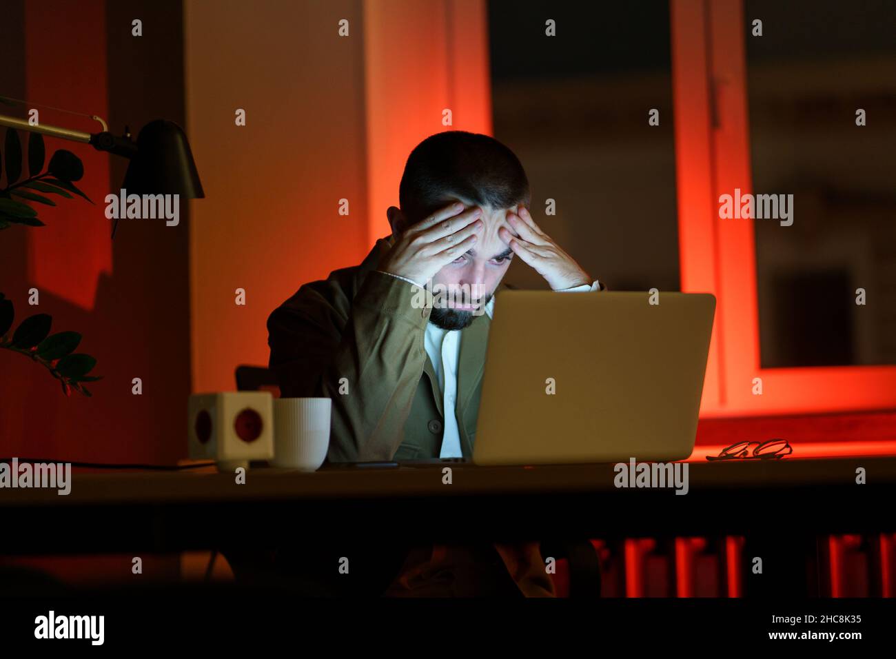 Verwirrt junger Geschäftsmann in der Nacht Büro Arbeit am Laptop-Computer erschöpft und müde von Fristen Stockfoto