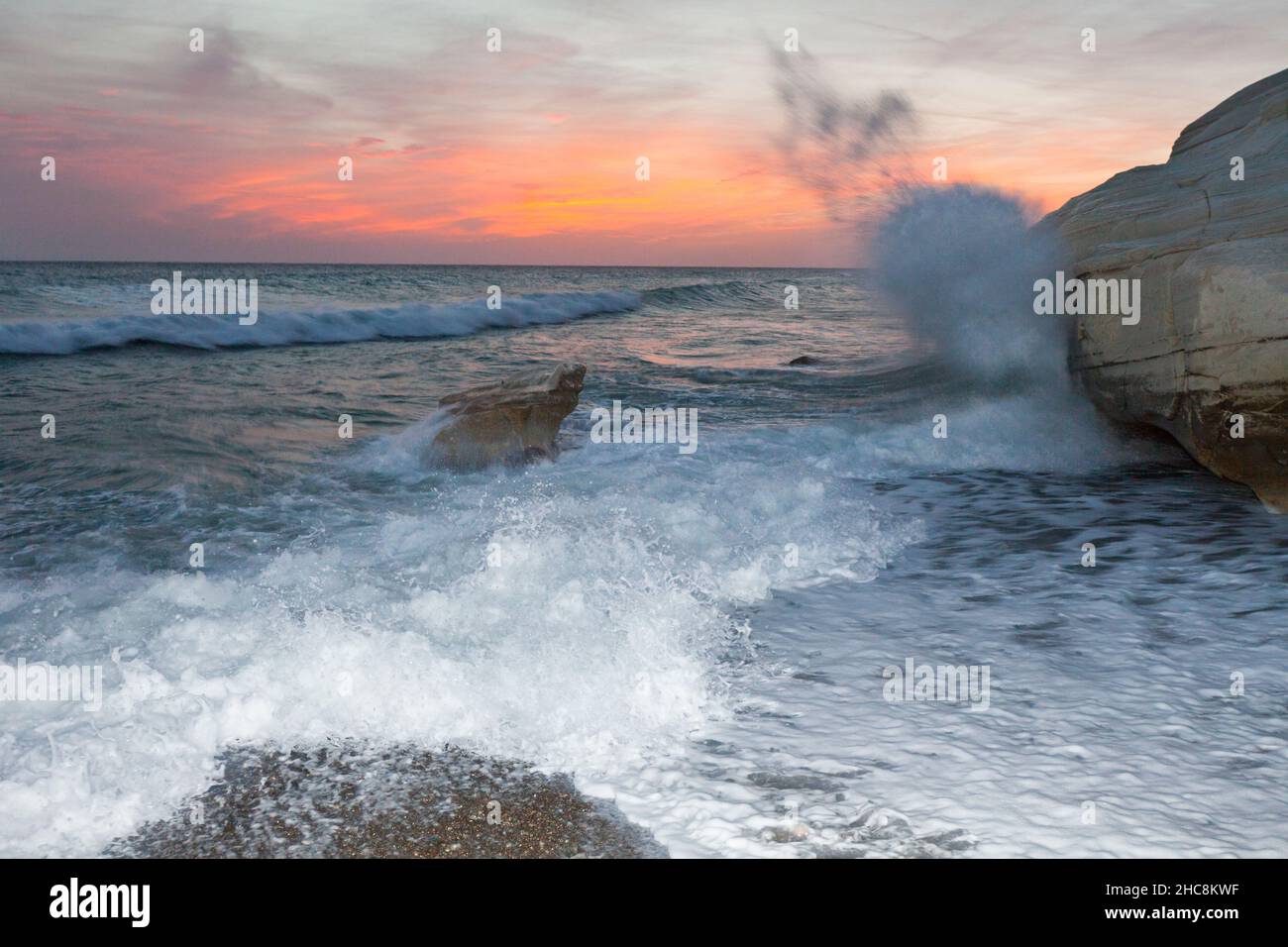 Wellen krachen an der felsigen Küste, Südküste neben Paphos, nach Sonnenuntergang, Insel Zypern, östliches Mittelmeer Stockfoto