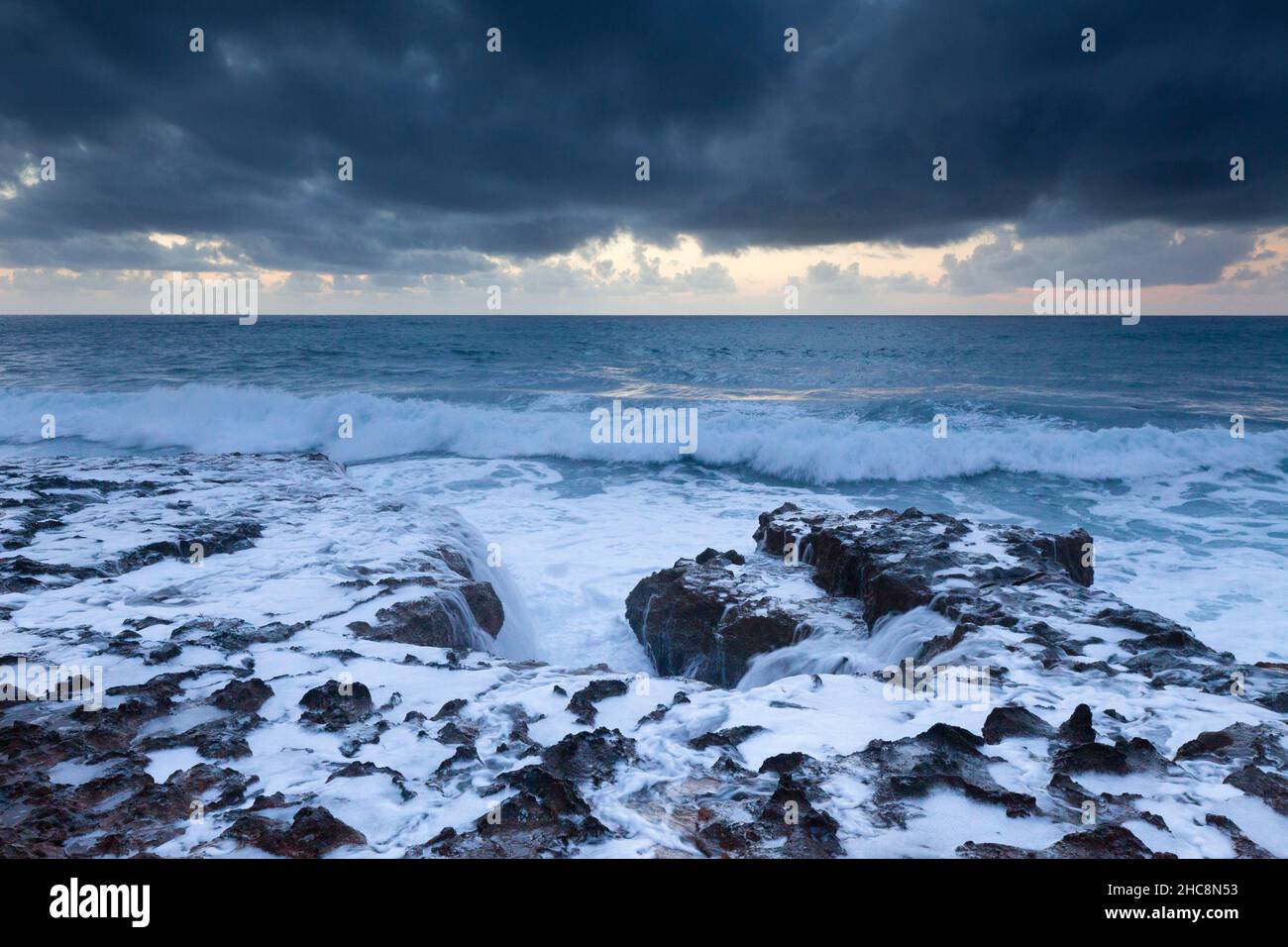 Stürmischer Himmel und Wellen, die an felsiger Küste, der Halbinsel Akamas, der Insel Zypern und dem östlichen Mittelmeer krachen Stockfoto