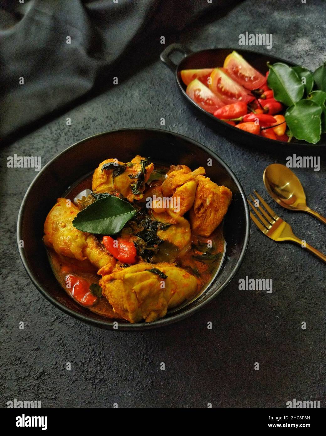 Ayam Woku oder Chicken Woku, ein traditionelles Gericht aus Manado, Nord-Sulawesi, Indonesien. Es wird aus Huhn mit verschiedenen Gewürzen gekocht. Stockfoto