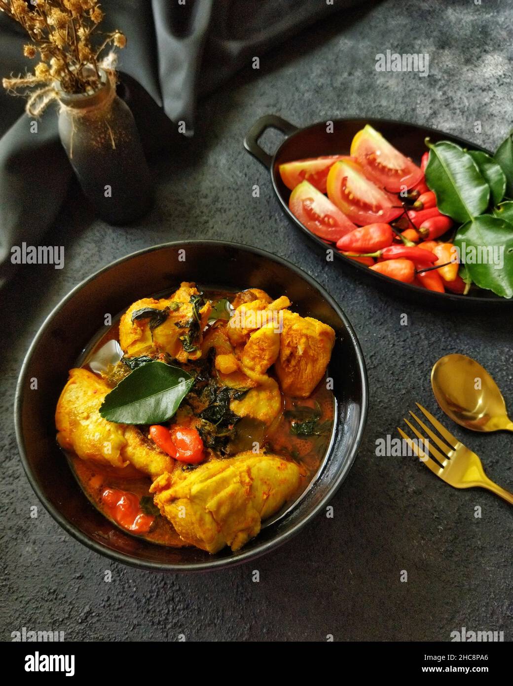 Ayam Woku oder Chicken Woku, ein traditionelles Gericht aus Manado, Nord-Sulawesi, Indonesien. Es wird aus Huhn mit verschiedenen Gewürzen gekocht. Stockfoto