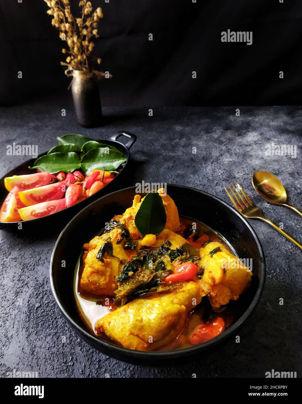 Ayam Woku oder Chicken Woku, ein traditionelles Gericht aus Manado, Nord-Sulawesi, Indonesien. Es wird aus Huhn mit verschiedenen Gewürzen gekocht. Stockfoto