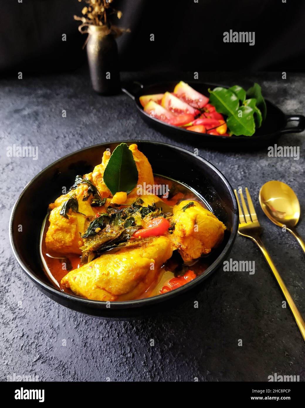 Ayam Woku oder Chicken Woku, ein traditionelles Gericht aus Manado, Nord-Sulawesi, Indonesien. Es wird aus Huhn mit verschiedenen Gewürzen gekocht. Stockfoto