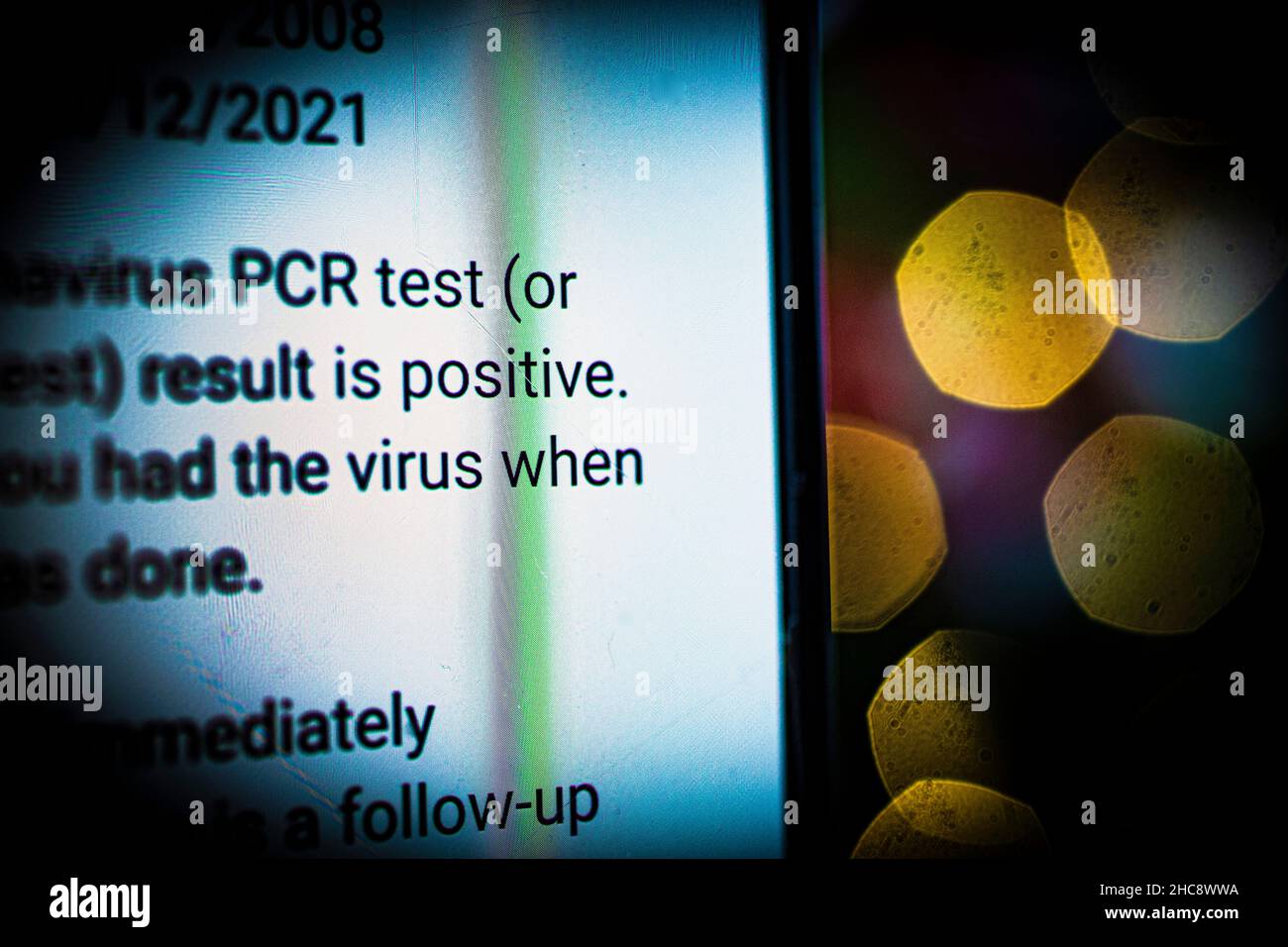 Nahaufnahme des Telefons mit positiver Meldung des NHS-Coronavirus-PCR-Tests Stockfoto