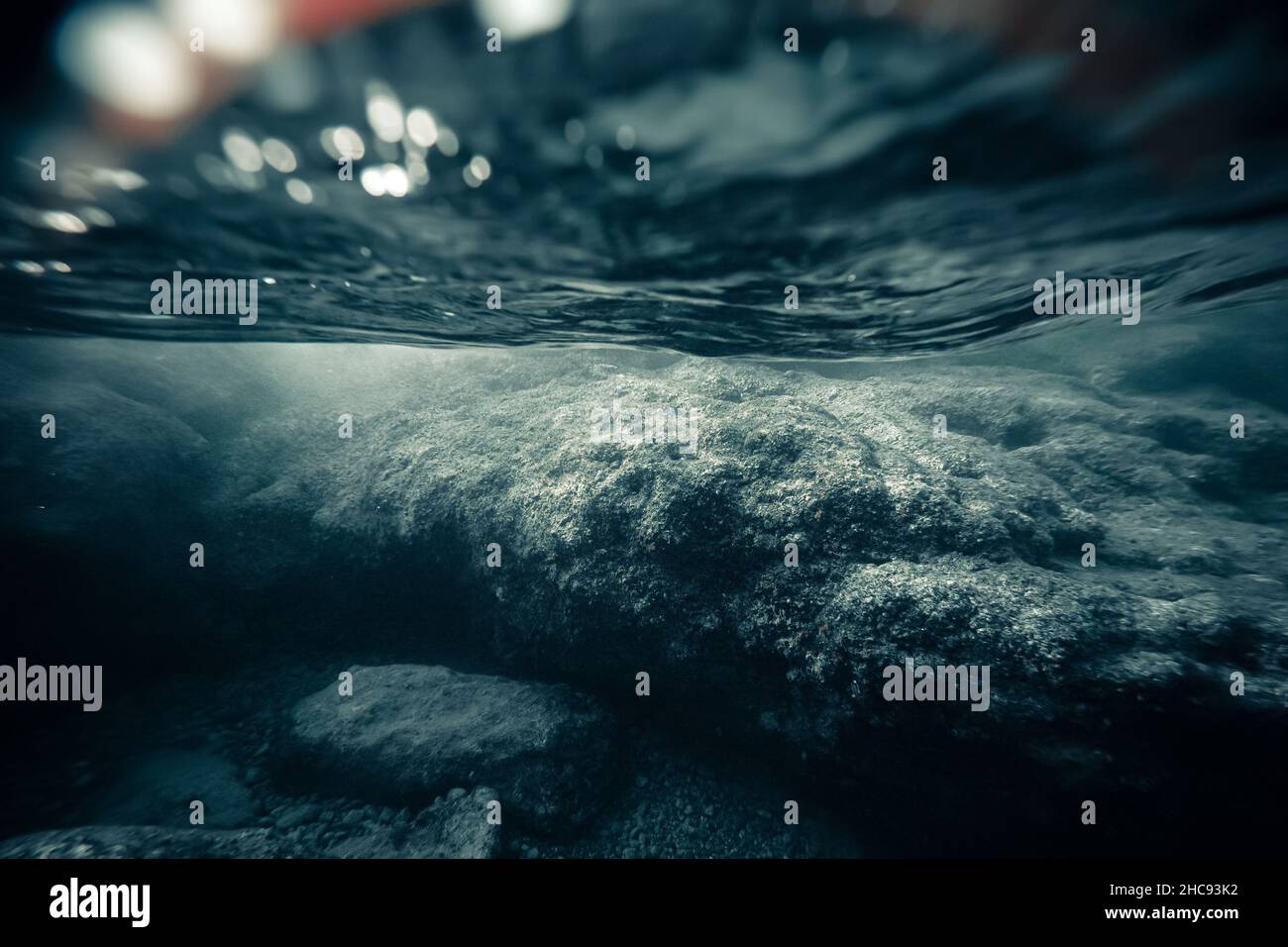 Eine einsame und dunkle mystische Unterwasserlandschaft mit großen Felsen an der flachen Küste. Geringe Tiefe und weicher Fokus. Düstere und launische Atmosphäre Stockfoto