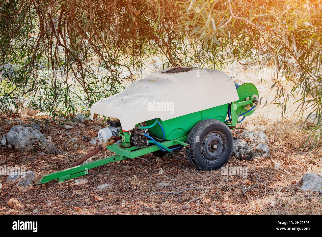 Bewässerungsbehälter Schubkarre zum Sprühen von Wasser oder Düngemitteln im Olivengarten. Landwirtschaft und Bewässerung Stockfoto