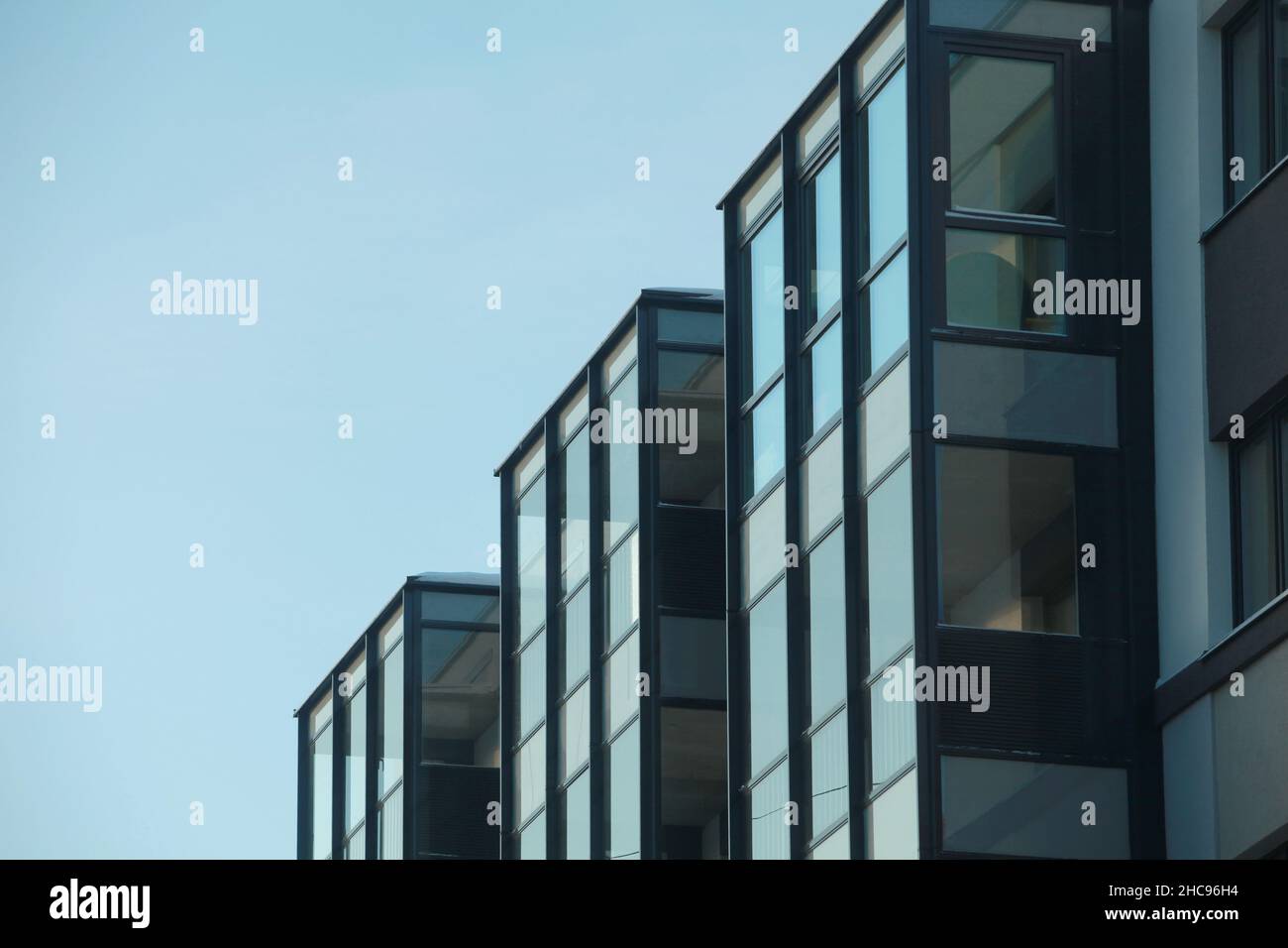 Gläsernes Gebäude mit tiefem Sichtwinkel am blauen Himmel, minimalistische Architektur Stockfoto