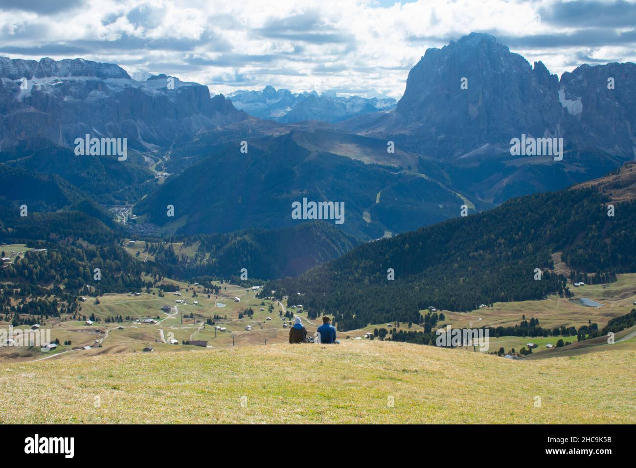 Paar sitzen mit Blick auf die Dolomiten in den europäischen Alpen. Gardena Pass, Italien Stockfoto