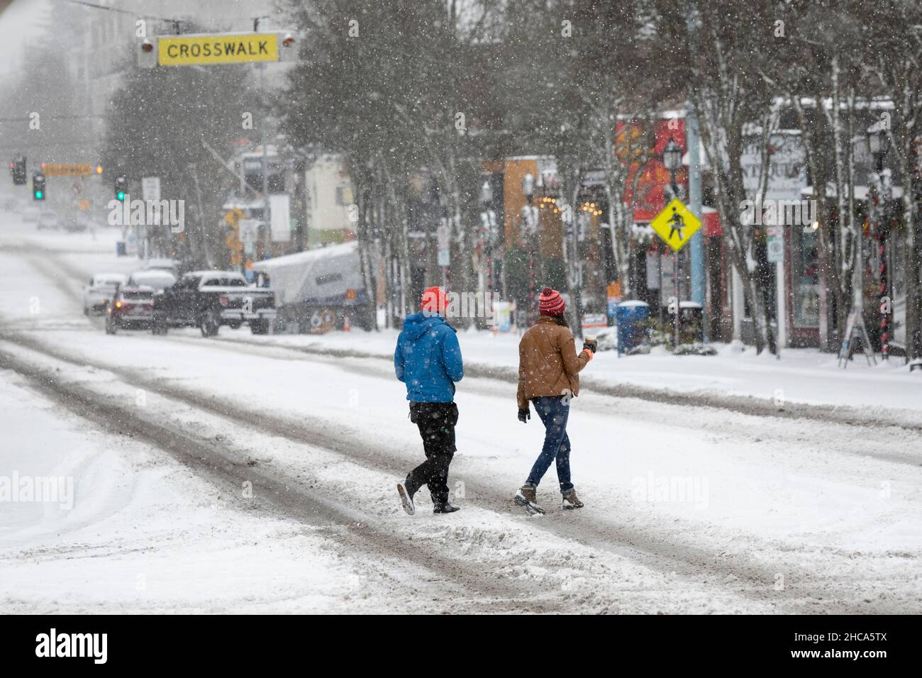 Seattle, Washington, USA. 26th Dez 2021. Fußgänger überqueren vorsichtig die West Seattle Junction, während am Sonntag, dem 26. Dezember 2021, ein Wintersturm Seattle trifft. Quelle: Paul Christian Gordon/Alamy Live News Stockfoto