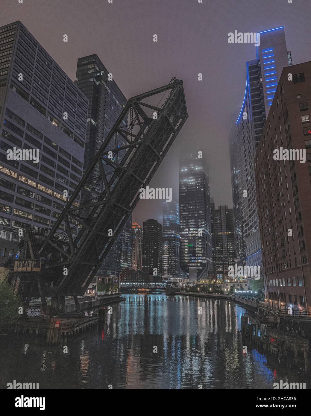 Vertikale Aufnahme der Eisenbahnbrücke der Kinzie Street, die nachts in der erhöhten Position gesperrt wurde Stockfoto