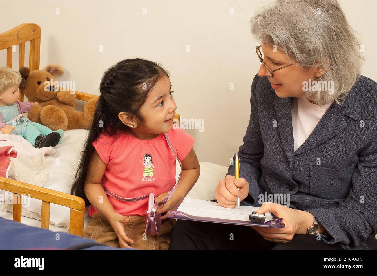 Forscher zu Hause Besuch bei drei Jahre altes Mädchen Interaktion mit ihr und Notizen Familie ist mexikanisch amerikanische Forscher ist weiß Stockfoto