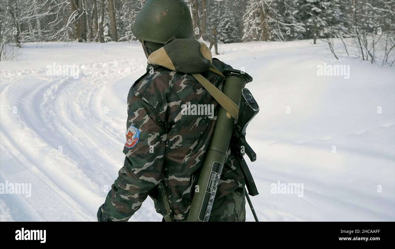 Soldat mit Waffen im kalten Wald. Winterkrieg und militärisches Konzept. Clip. Soldaten im Winterwald auf Skiern mit Gewehren. Militärische Übungen in der Stockfoto