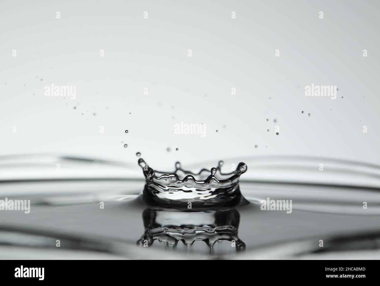 Wasser spritzte Form der Krone auf hellem Hintergrund Stockfoto