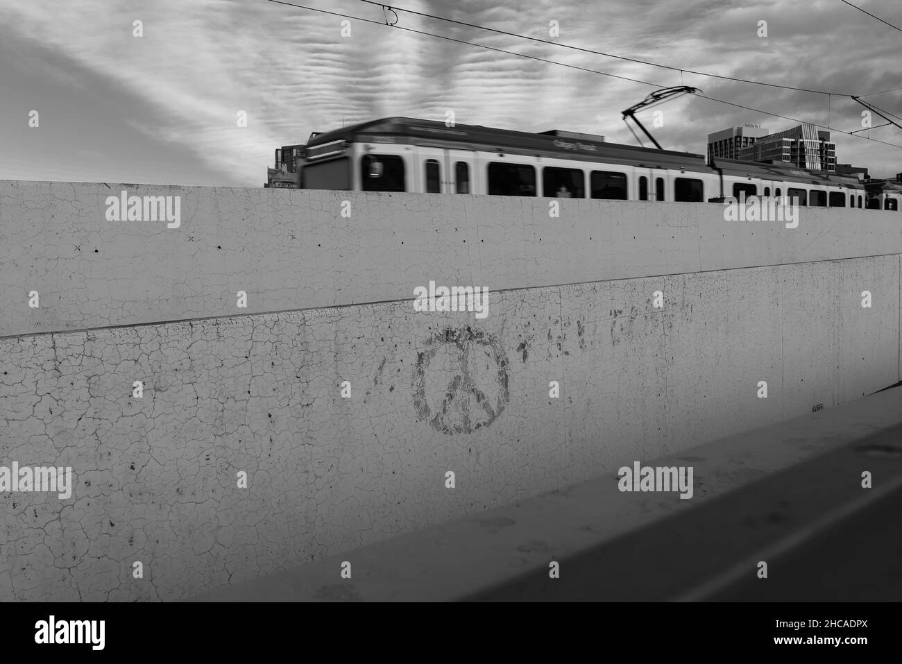 Symbol des Friedens auf einer Zementwand mit einem Zug im Hintergrund Calgary, Alberta Stockfoto