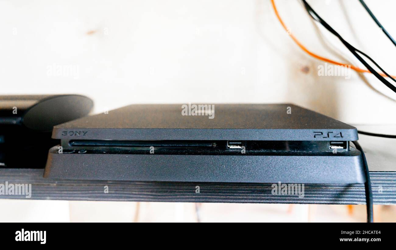 Die PS4-Konsole, eingesteckt, auf dem Regal Stockfoto