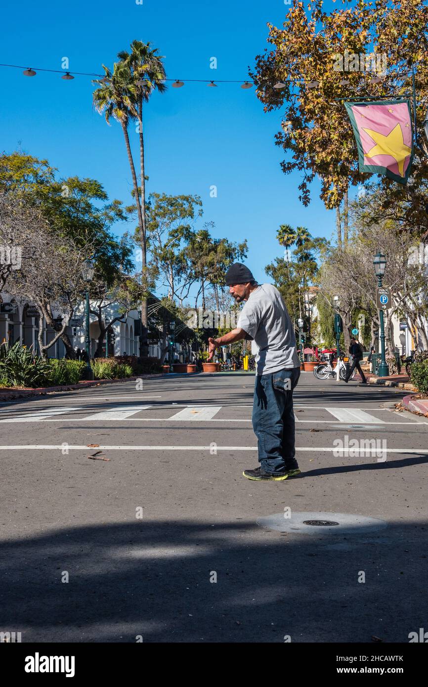 Ein hispanischer erwachsener Mann führt am Morgen Tai Chi mitten in der State Street, Santa Barbara, Kalifornien, auf. Stockfoto