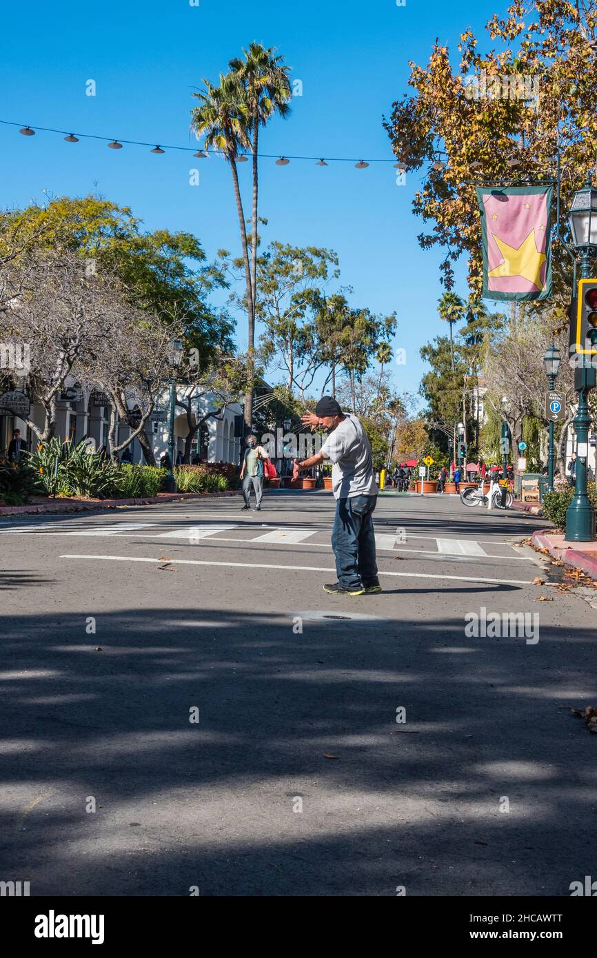 Ein hispanischer erwachsener Mann führt am Morgen Tai Chi mitten in der State Street, Santa Barbara, Kalifornien, auf. Stockfoto