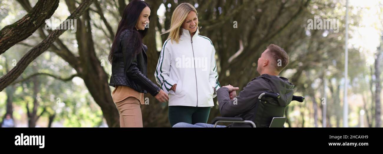 Mann im Rollstuhl und lachende Frau im Park Stockfoto