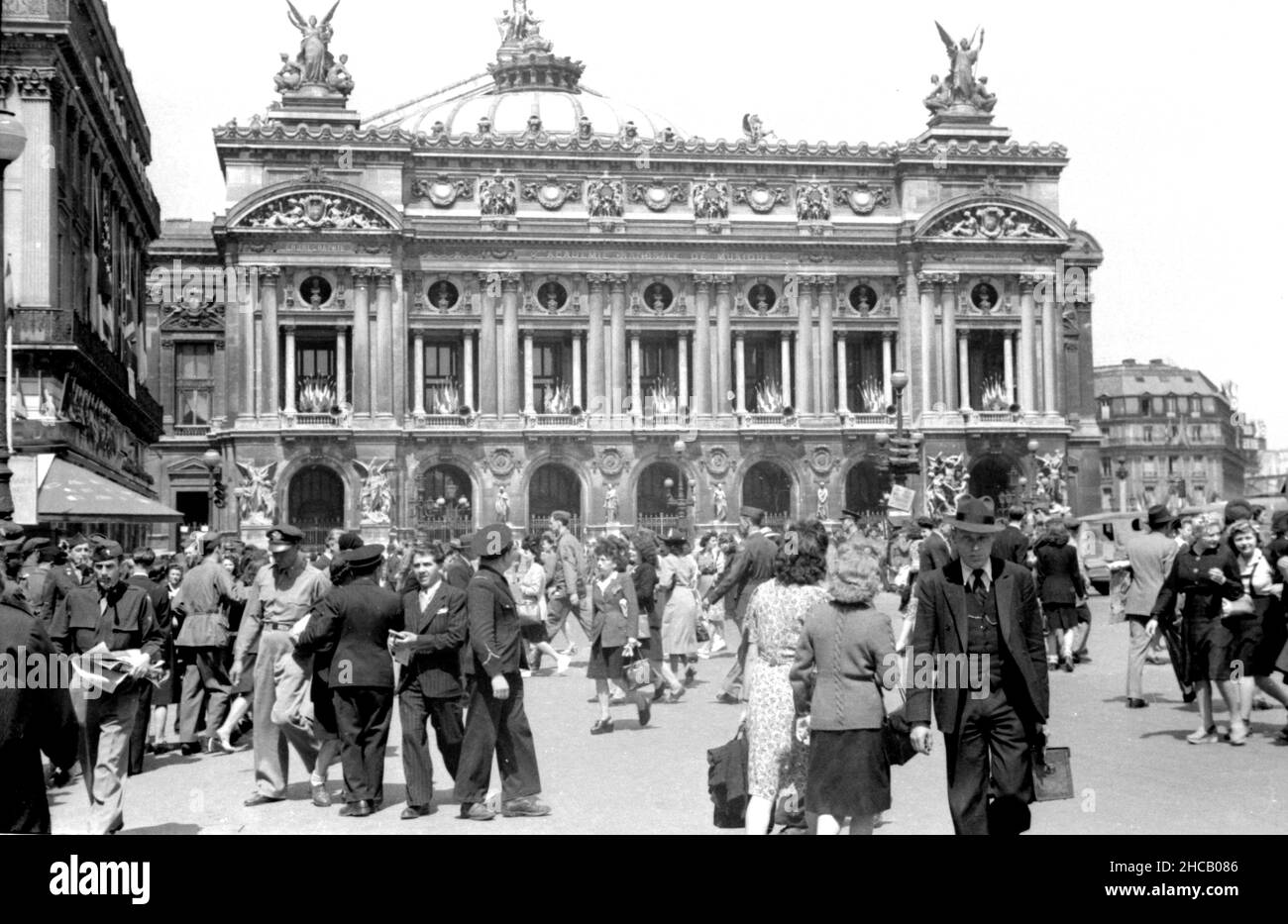 Pariser feiern am 3 1945. April auf dem Place de L’Opera. Dies war ein Tag der Feierlichkeiten in Paris, der mit 100.000 Menschen gipfelte, die Charles De Gaulle bei der Wiederbelebung des französischen Militärs beobachteten. De Gaulle restaurierte die Farben von 131 Einheiten der französischen Kampfdienste. Der schwedische Journalist Sven Auren berichtete: „an jenem Aprilmorgen waren die Pariser auf dem Place de la Concord zu dem Mann raus…, wo sich ein veritabler Wald aus weißen Flaggenstäben befand, die alle die Trikolore flogen.“ Stockfoto