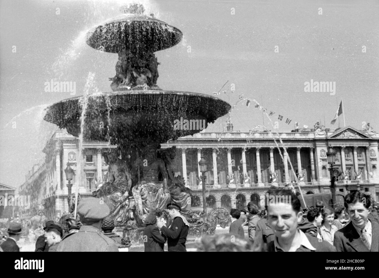 Feier am Brunnen auf dem Place de la Concorde, April 3 1945. Dies war ein Tag der Feierlichkeiten in Paris, der mit 100.000 Menschen gipfelte, die Charles De Gaulle bei der Wiederbelebung des französischen Militärs beobachteten. De Gaulle stellte die Farben von 131 Einheiten der französischen Kampfdienste wieder her. Der schwedische Journalist Sven Auren berichtete: „an jenem Aprilmorgen waren die Pariser auf dem Place de la Concorde zu dem Mann raus…dort war ein wahrer Wald aus weißen Flagstaffs, die alle die Trikolore flogen.“ Stockfoto
