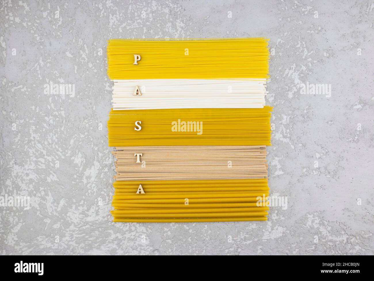Draufsicht auf die lange Pasta und Paghetti, die zusammen mit dem Wort der Holzbuchstaben - Pasta angelegt wurden Stockfoto