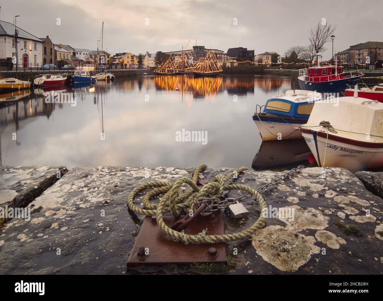 Dramatische Wolkenlandschaft mit alten Holzbooten an Docks in Galway, Claddagh, Irland Stockfoto